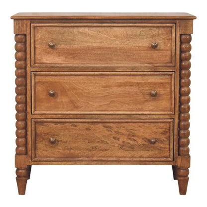 Commode en manguier massif teinte ambre, trois tiroirs à boutons ronds et pieds bobine sculptés
